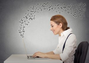 Woman sitting at desk in office working on laptop computer