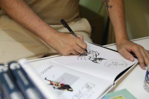Issac Sanchez firmando su última obra, 'Baños Pleamar' (Ed. Dolmen)